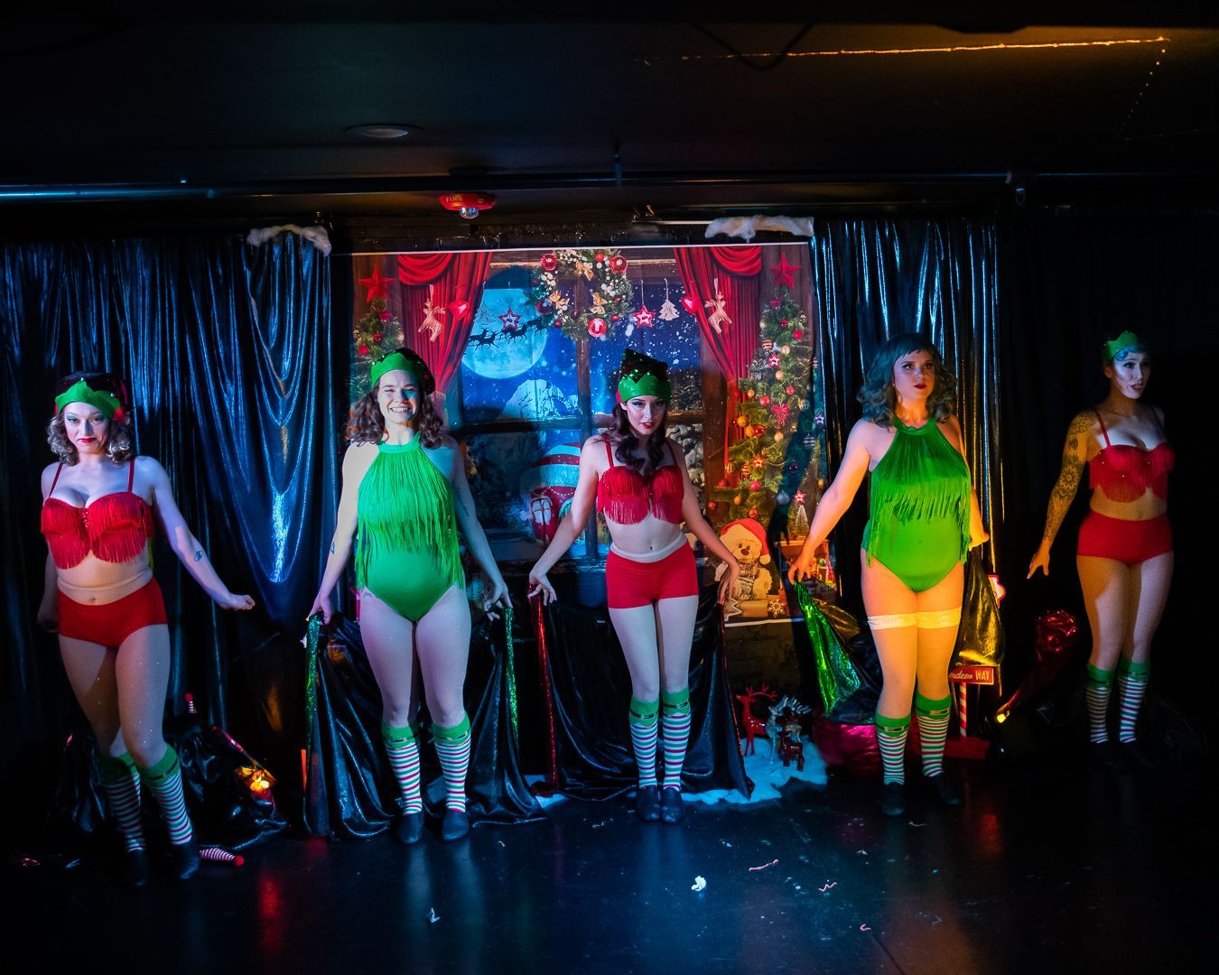 A group of women are standing on a stage holding hands.