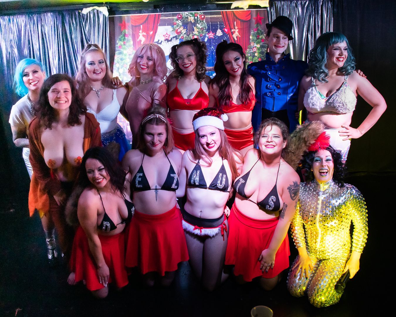 A group of women posing for a picture with one wearing a santa hat