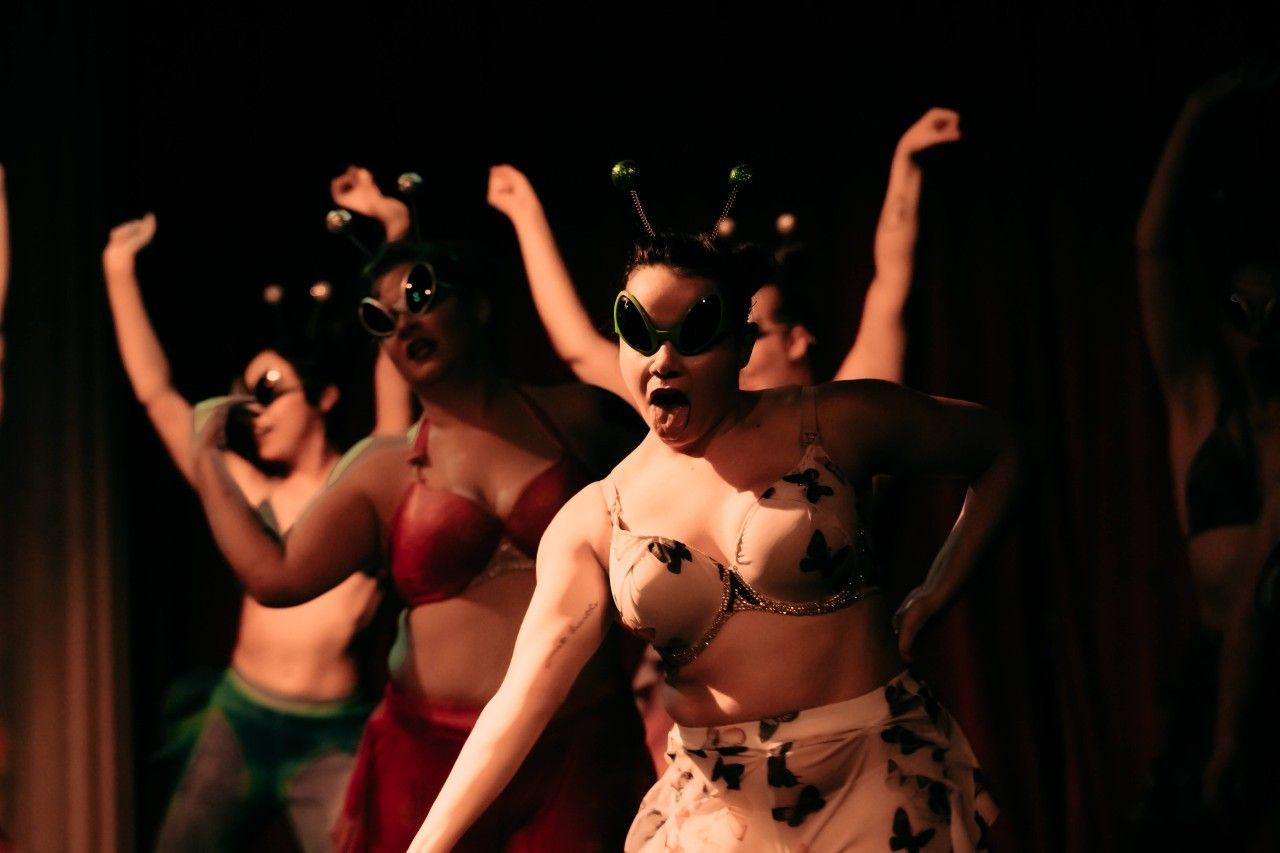 A group of women are dancing in a dark room