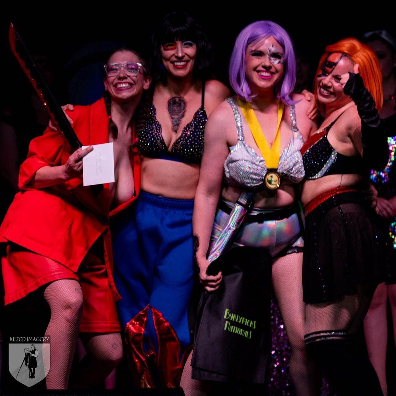 A group of women are posing for a picture and one of them is wearing a purple wig
