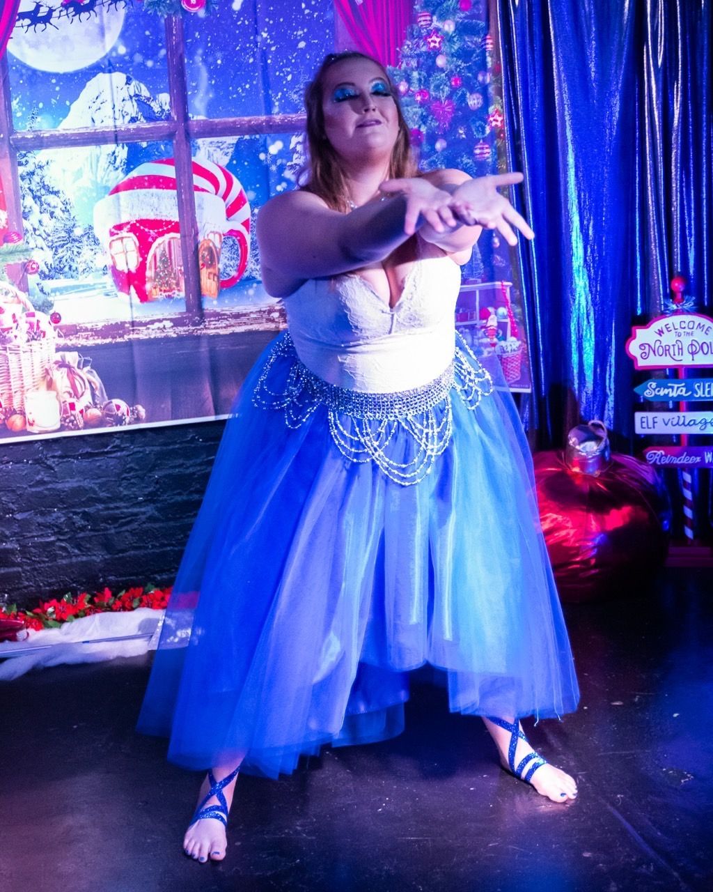 A woman in a blue dress is dancing on a stage