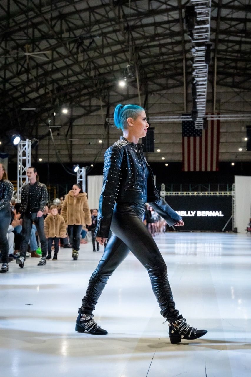 A woman with blue hair is walking on a ice rink.