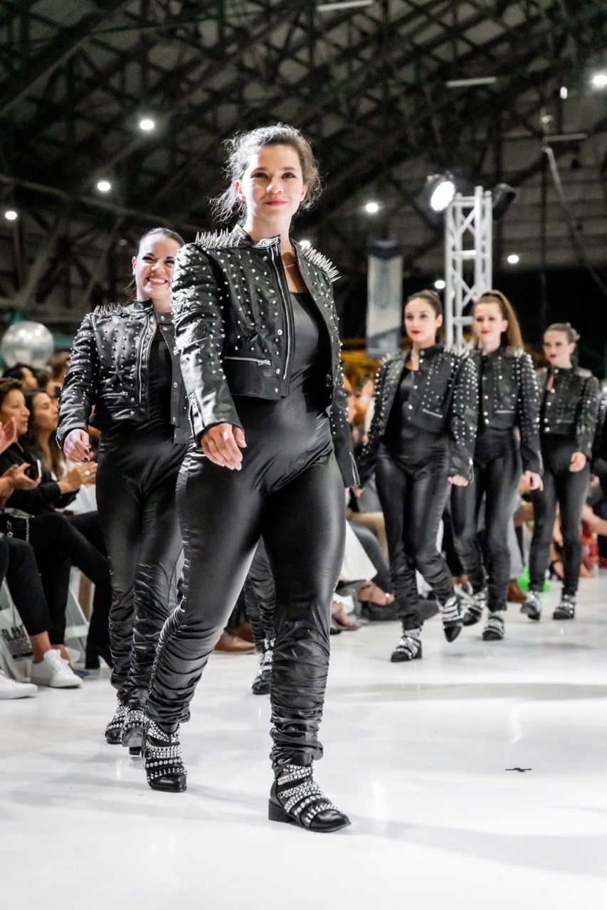 A group of women are walking down a runway at a fashion show.