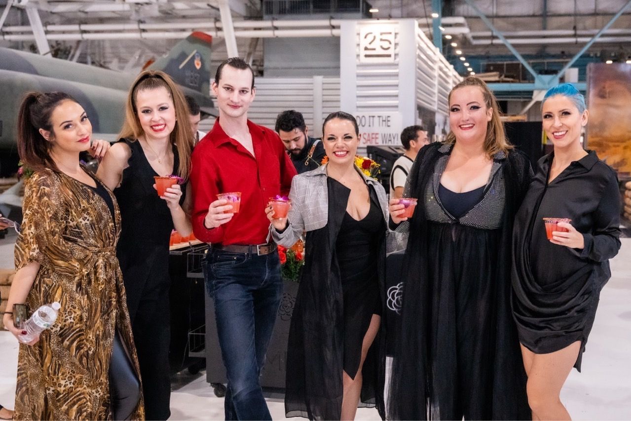 A group of people standing next to each other holding drinks.