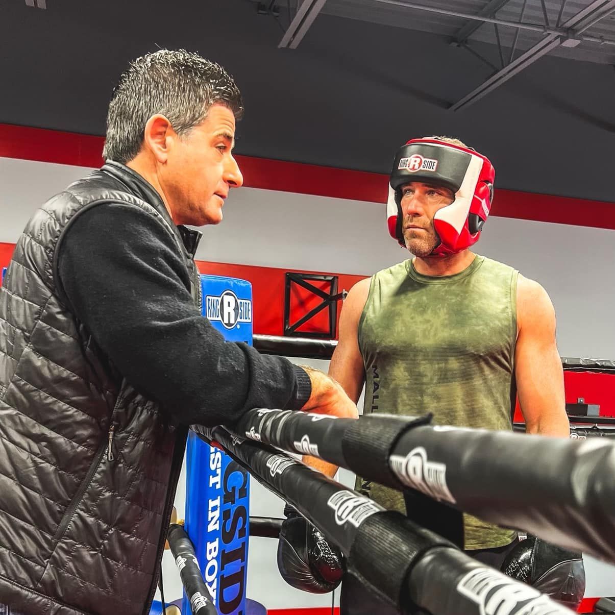 Trainer and boxer standing around the ring at champion boxing & fight club