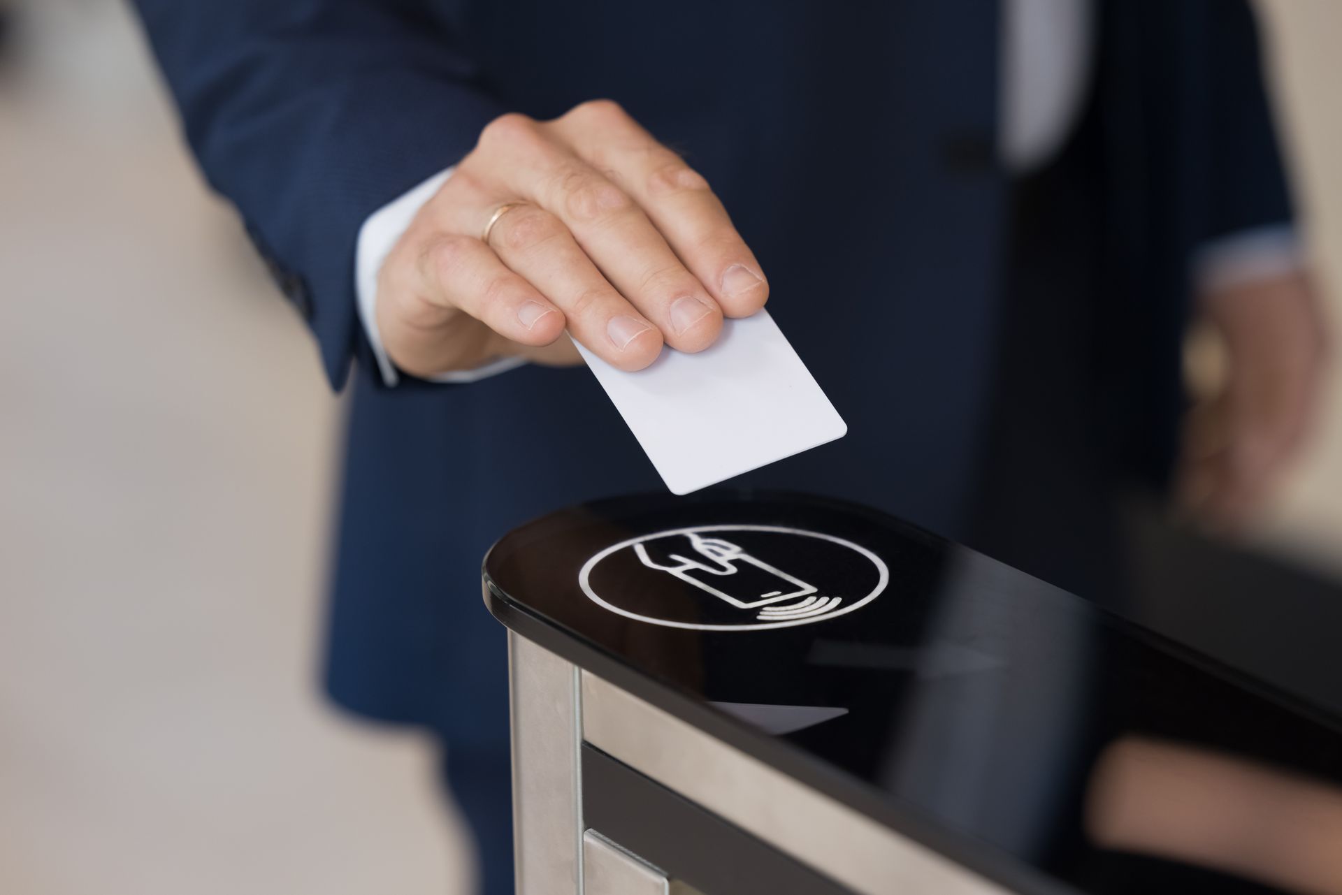 Man in suit using access card at a turnstile.