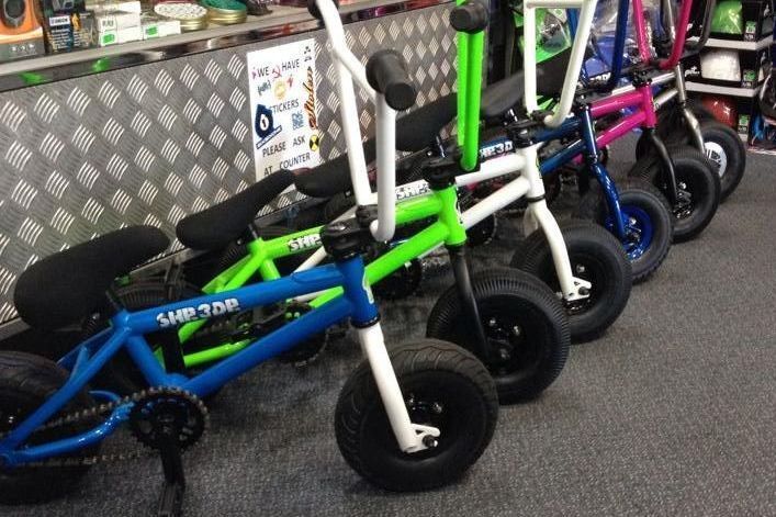 Five Colourful Mini BMX Bikes, Including Blue, Green, and Pink, Lined up Inside a Store — Freedom Sports in Bundaberg Central, QLD
