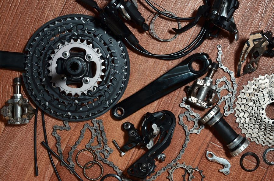A Bunch of Bicycle Parts Are Laying on a Wooden Floor — Freedom Sports in Bundaberg Central, QLD