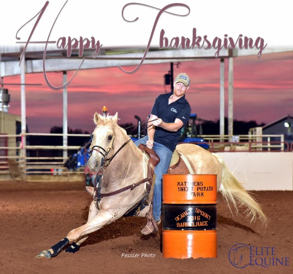 A man riding a horse next to an orange barrel with the words happy thanksgiving on it