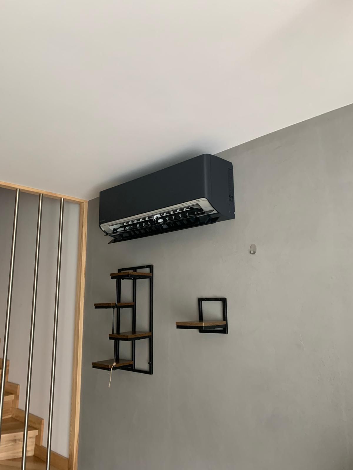 Salon ze schodami i klimatyzacją zamontowaną na ścianie.