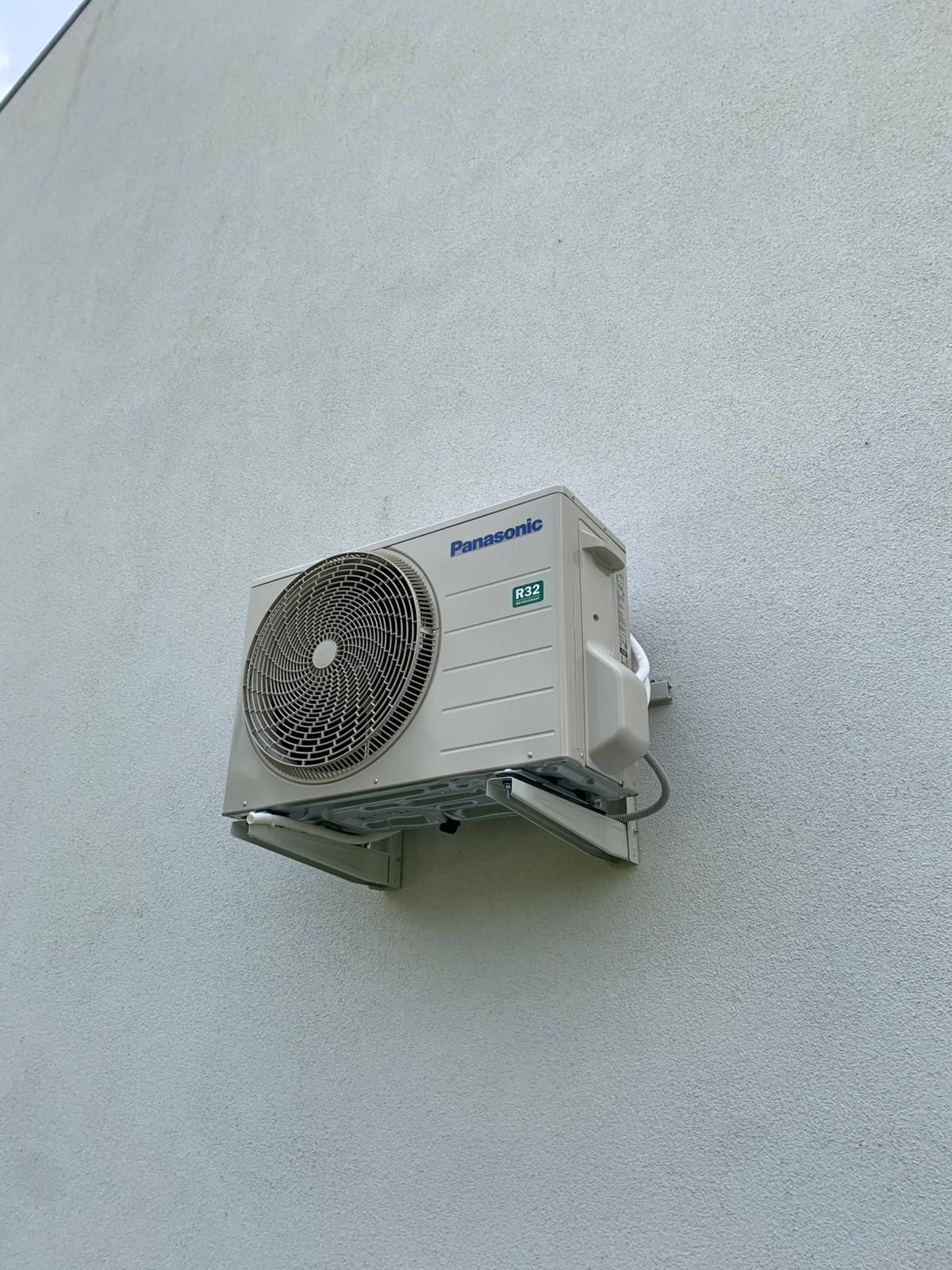 Klimatyzator Panasonic jest zamontowany na ścianie budynku.