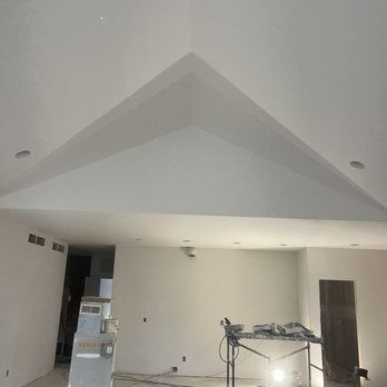 White drywall ceiling with a recessed, angular feature; a partially constructed room.