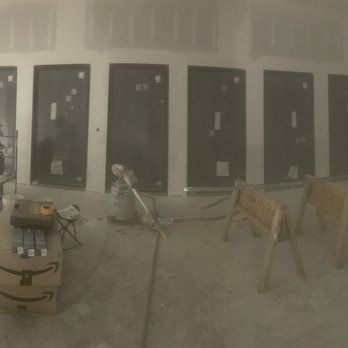 Interior of a building under construction, with doors and construction materials visible.