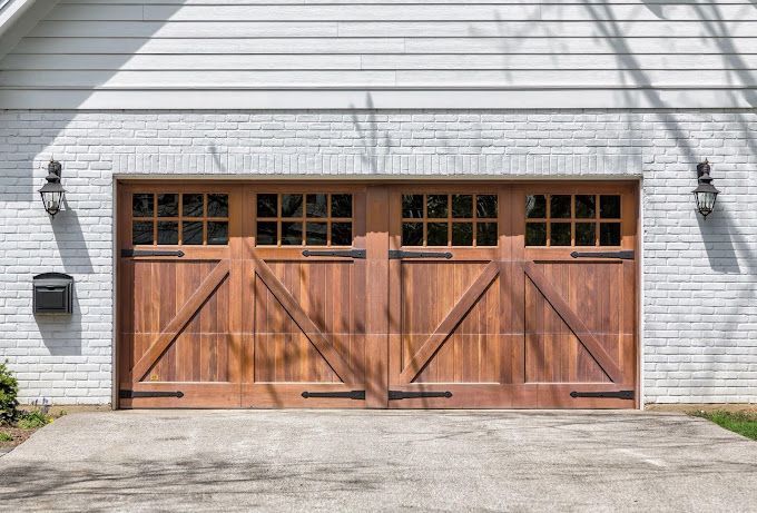 A white brick house with a wooden garage door.