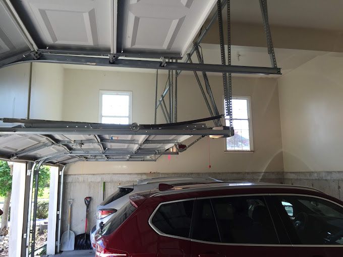 A red suv is parked in a garage with the door open.