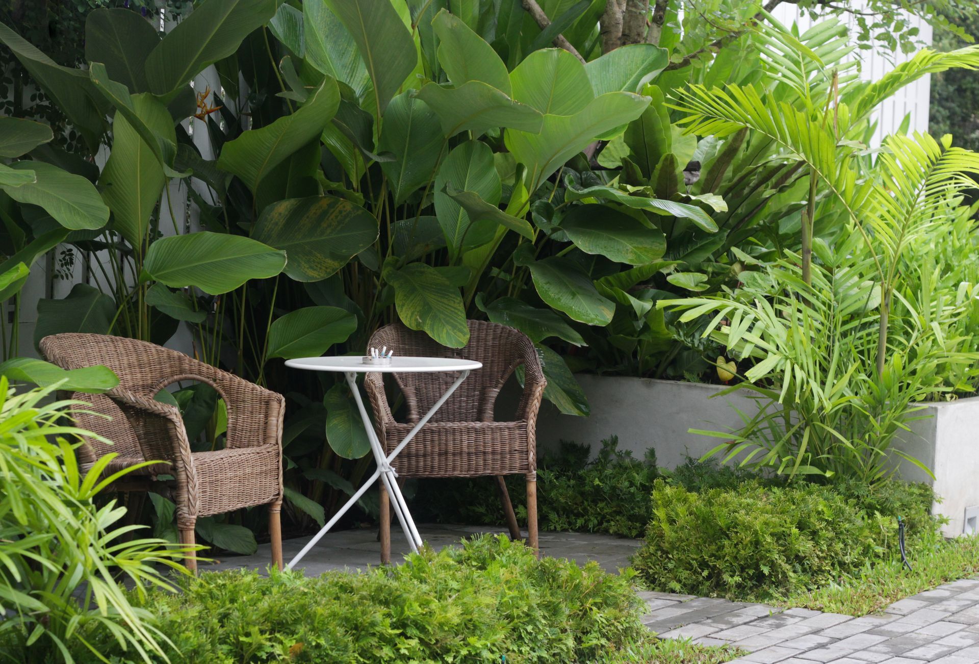There is a table and chairs in the middle of the garden.