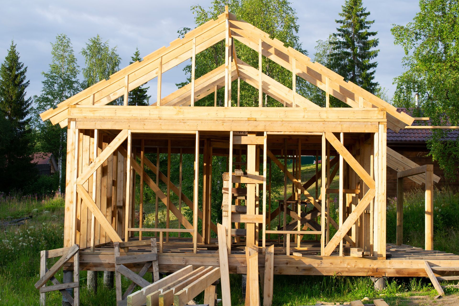 A wooden house is being built in the middle of a forest.