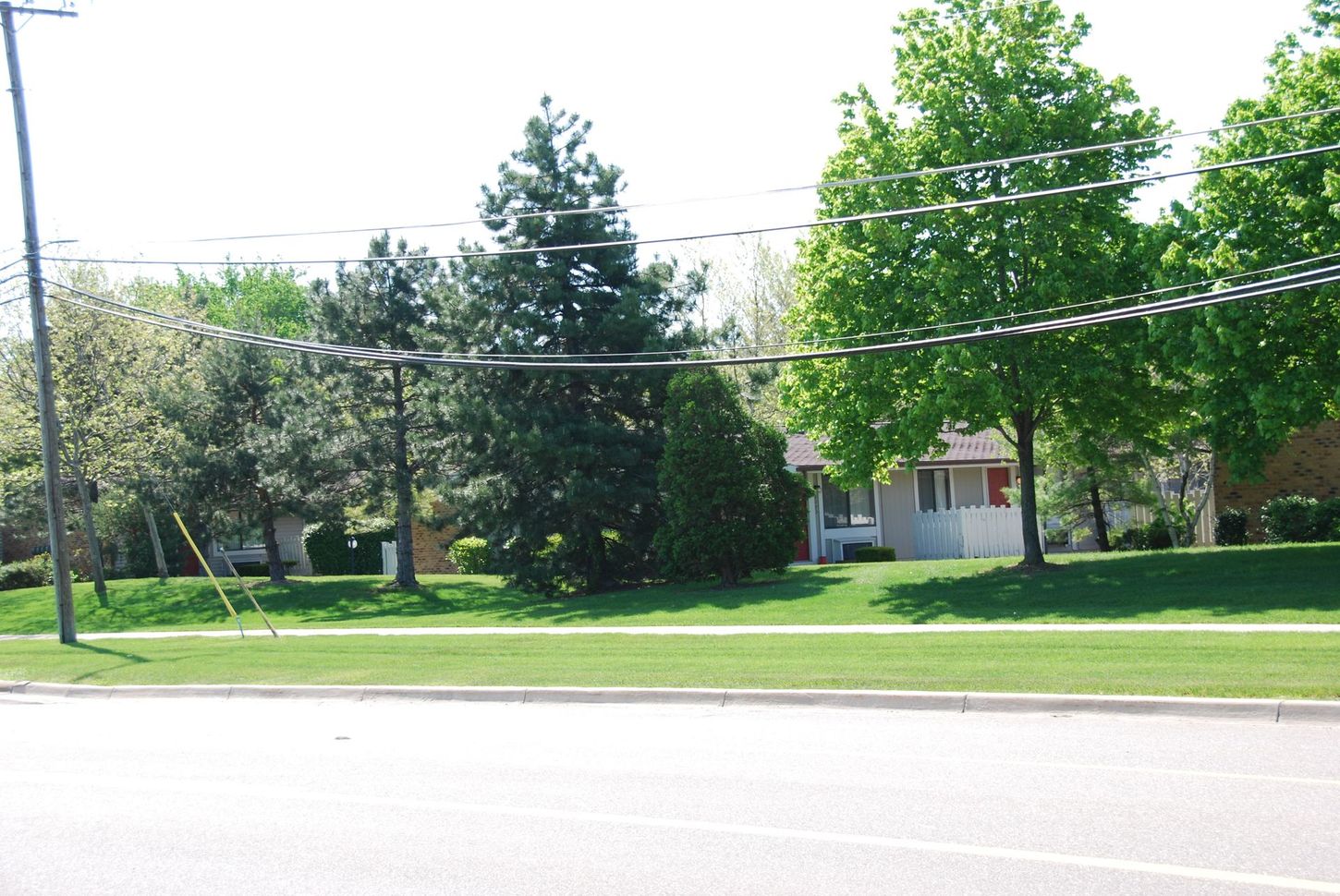 A white house sits on the corner of a residential street