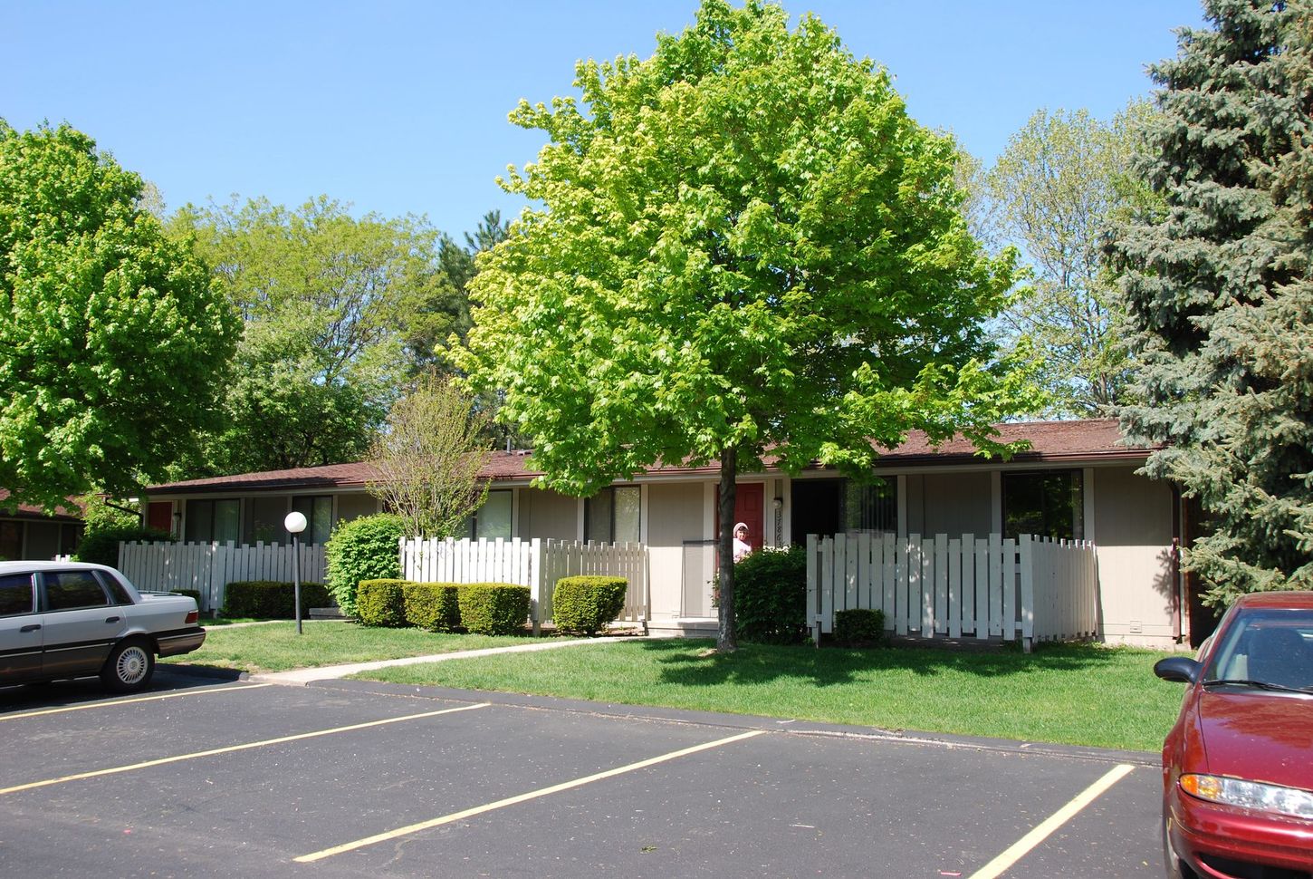 A red car is parked in front of a house