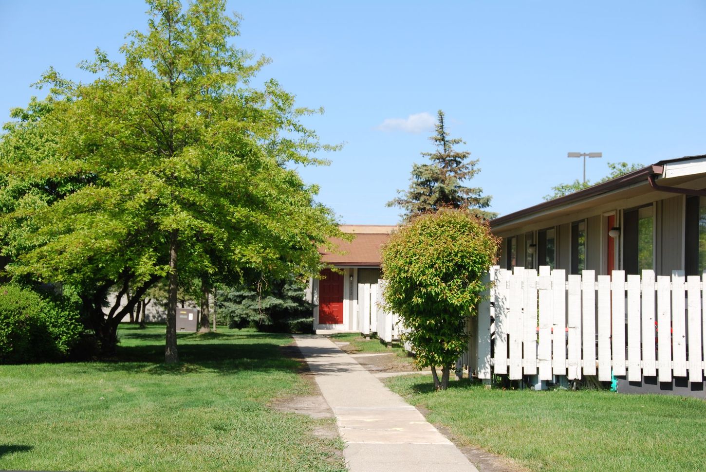 A house with a white picket fence and a red door