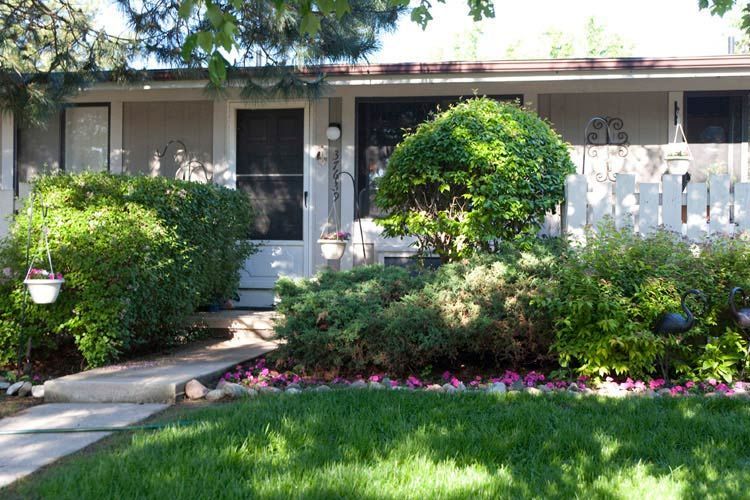 A house with a white picket fence and a lush green lawn