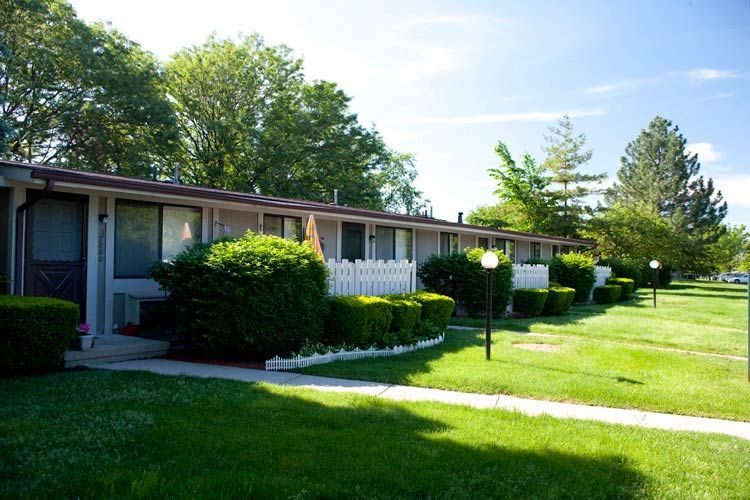 A row of houses with a white picket fence