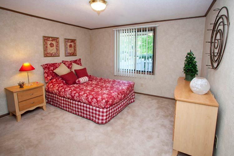 A bedroom with a large bed and a dresser