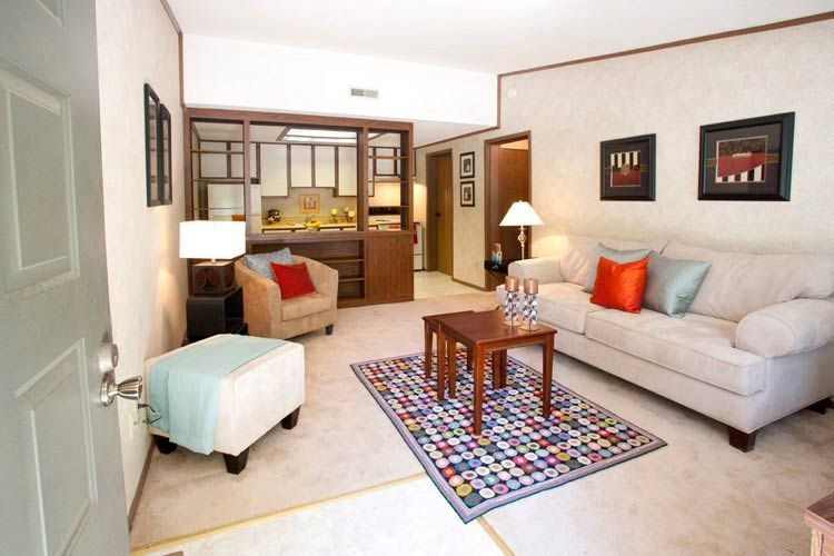 A living room with a couch and chairs and a rug