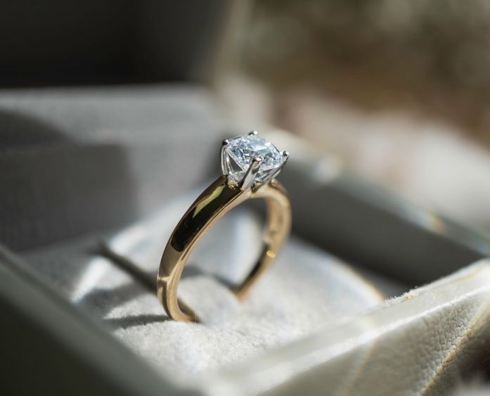 A gold ring with a diamond in a box