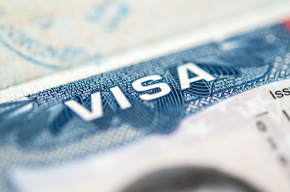 A close up of a visa on top of a passport.