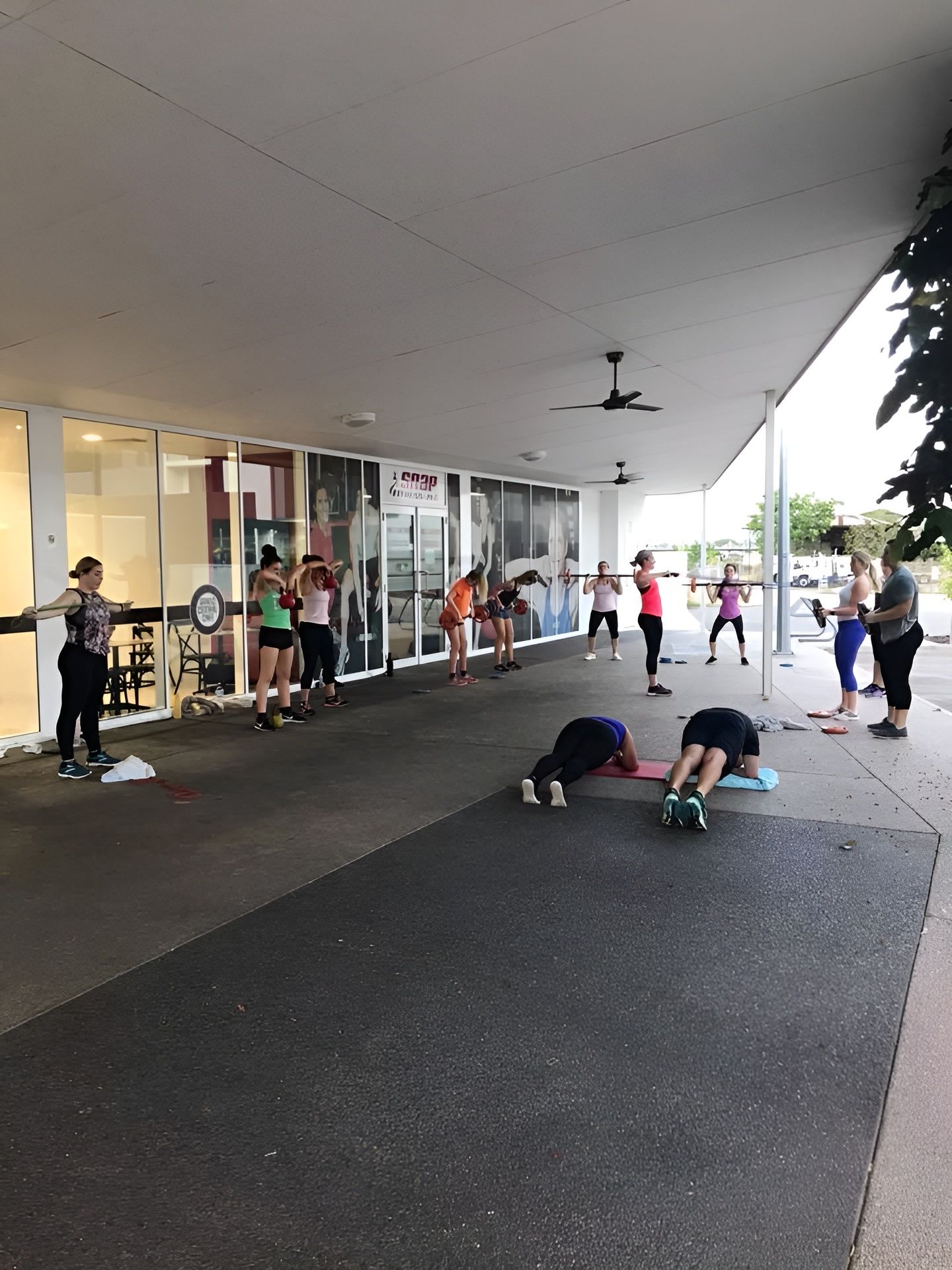A Group of People Are Doing Exercises Outside of a Building — Health First Townsville In Townsville, QLD