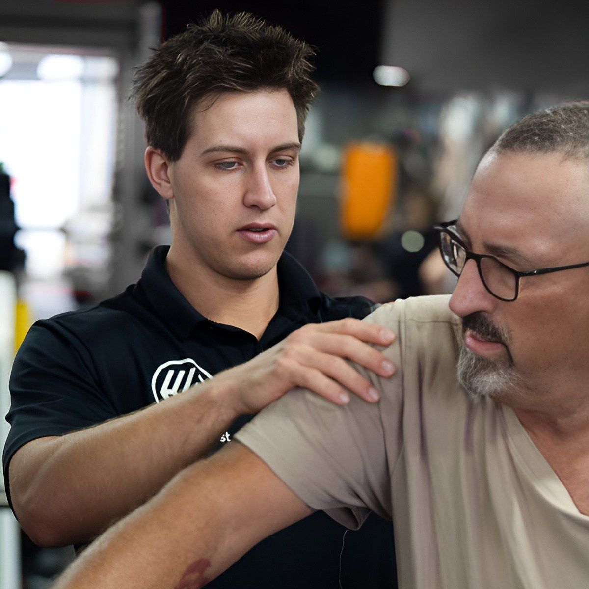 A Man Wearing Glasses and a Black Shirt With the Letter W on It β Health First Townsville In Townsville, QLD