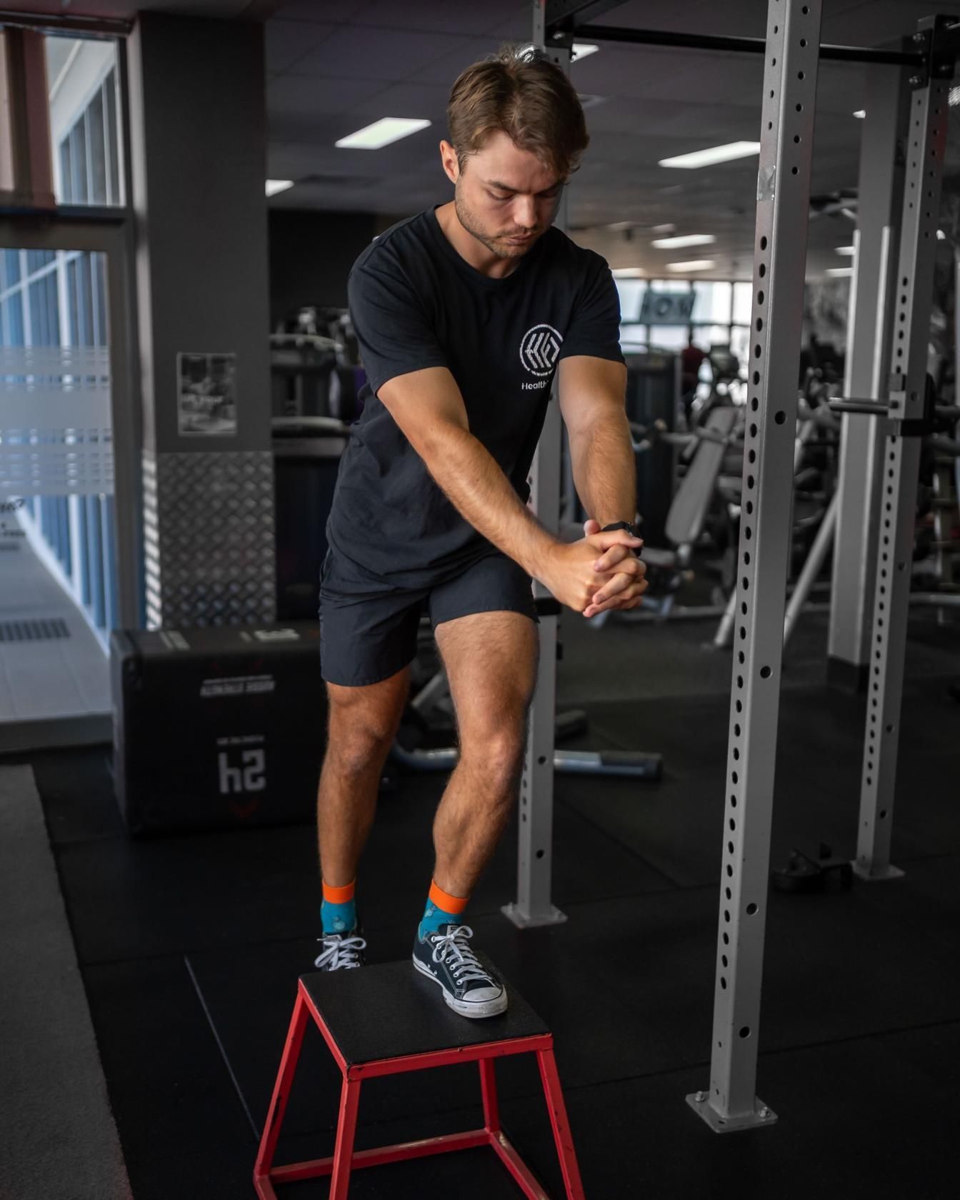 A Man is Standing on a Red Box in a Gym — Health First Townsville In Townsville, QLD