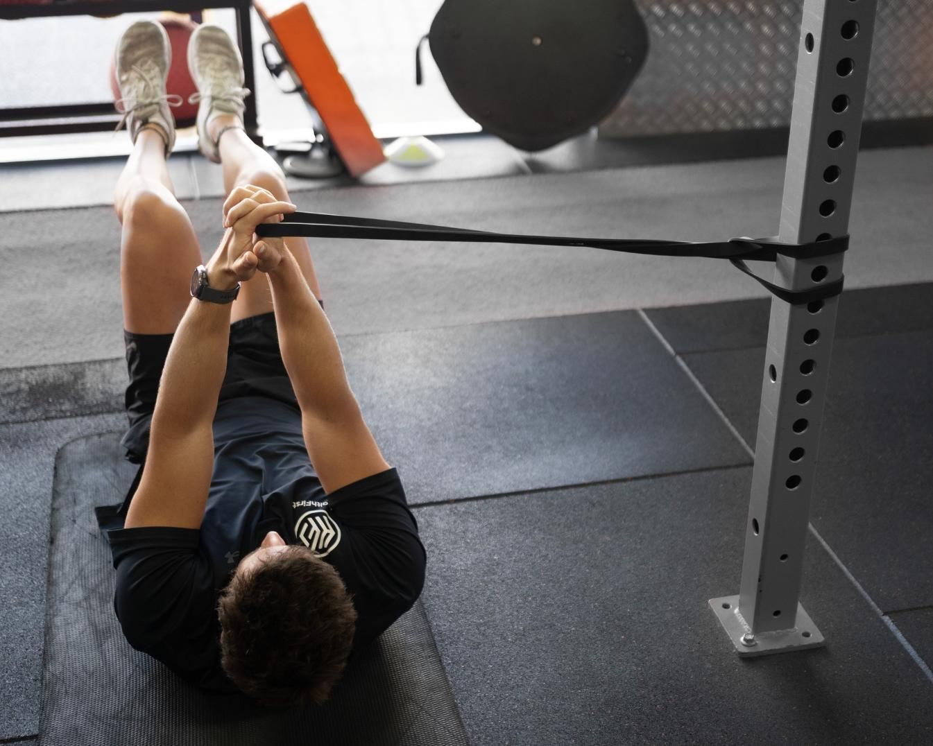 A Man is Laying on the Floor Stretching His Legs — Health First Townsville In Townsville, QLD