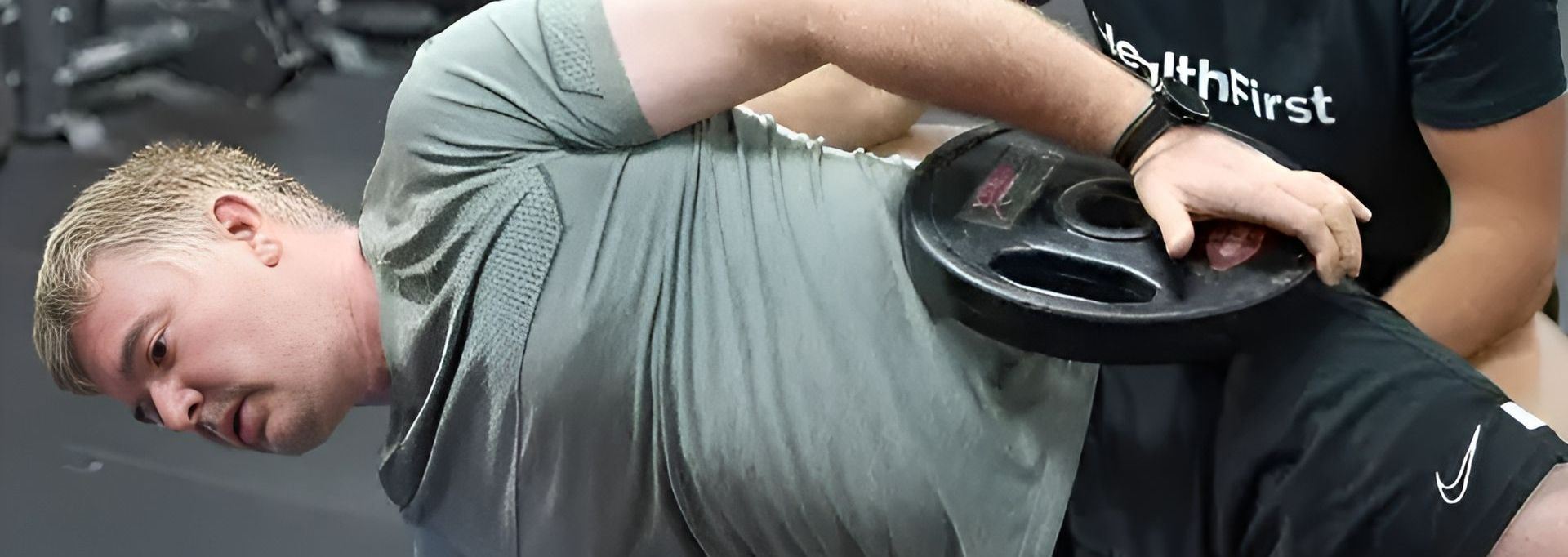 A Man is Laying on the Floor With a Barbell on His Back β Health First Townsville In Townsville, QLD
