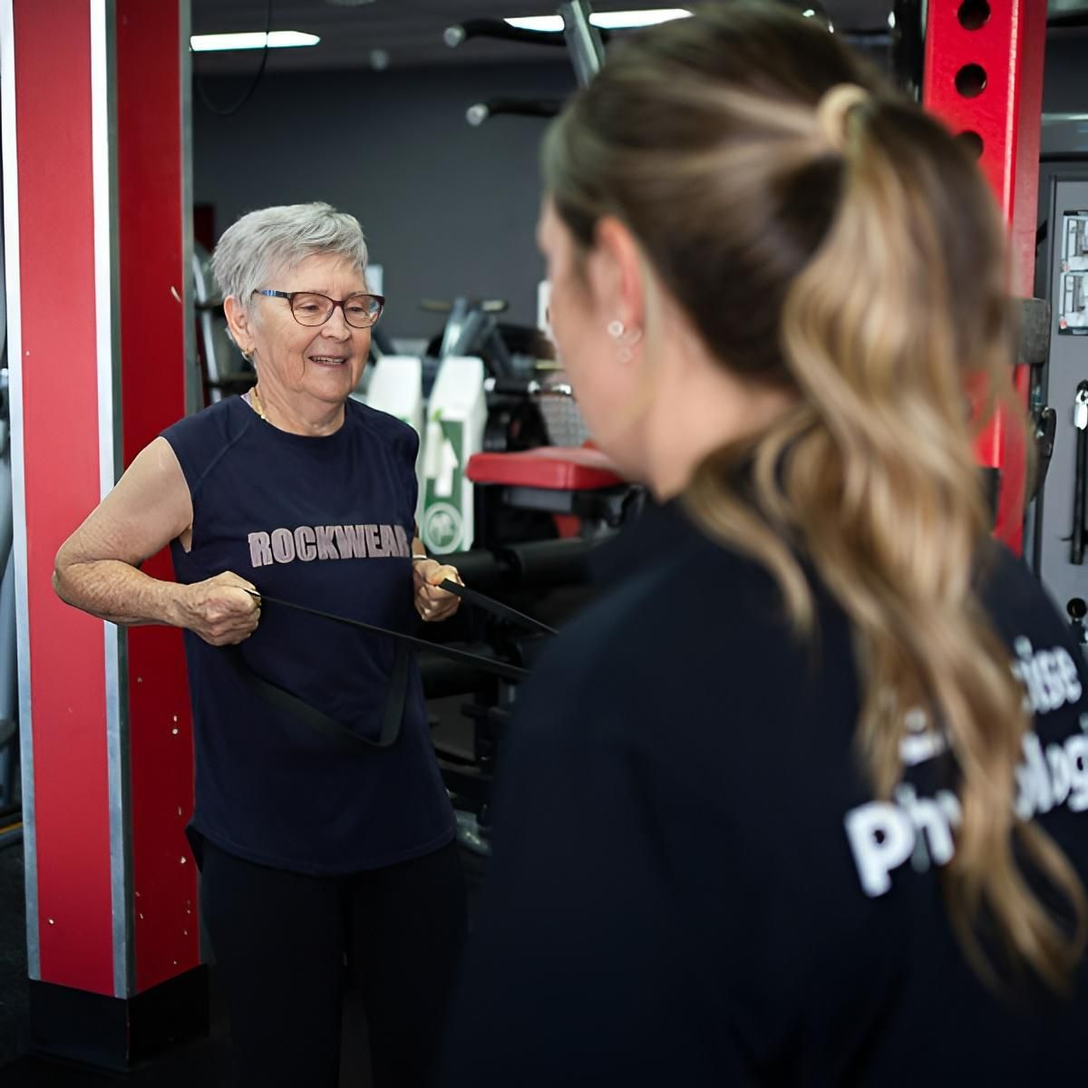 A Woman Wearing a Shirt That Says Rockwell is Talking to Another Woman in a Gym — Health First Townsville In Townsville, QLD