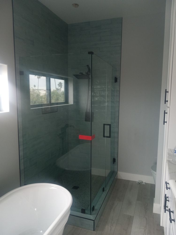 A bathroom with a tub and a shower with a glass door.