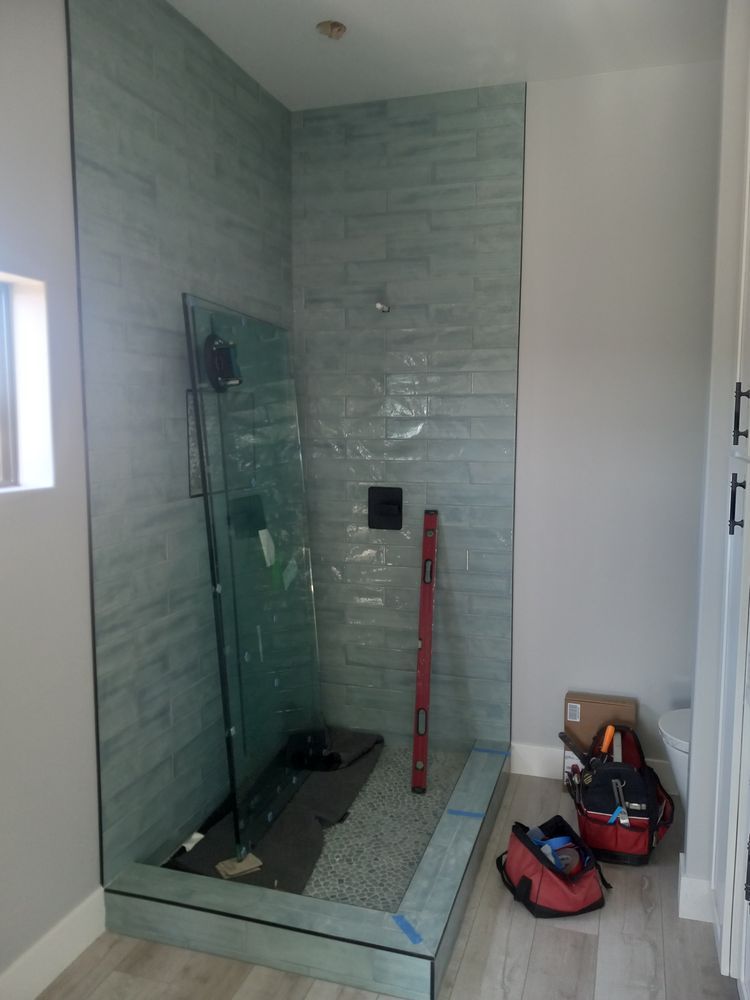 A bathroom with a walk in shower and a red level.