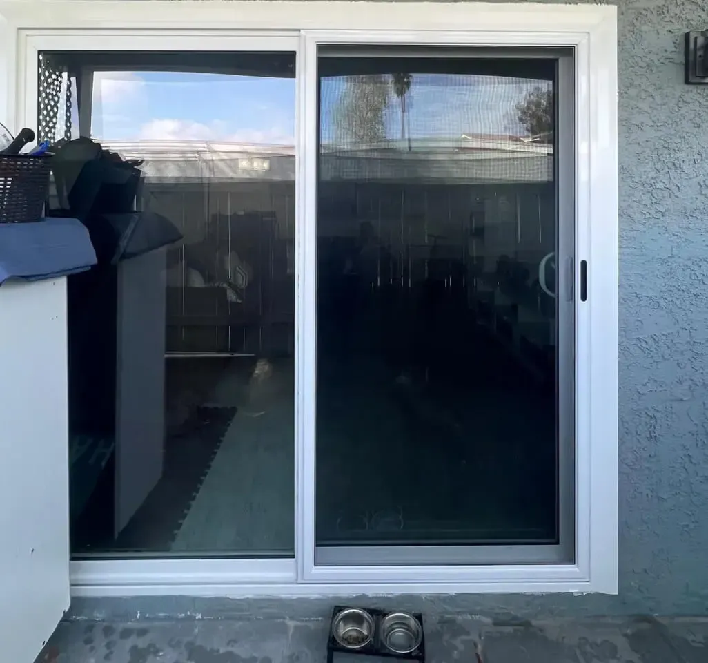 A white sliding glass door is open to a patio.