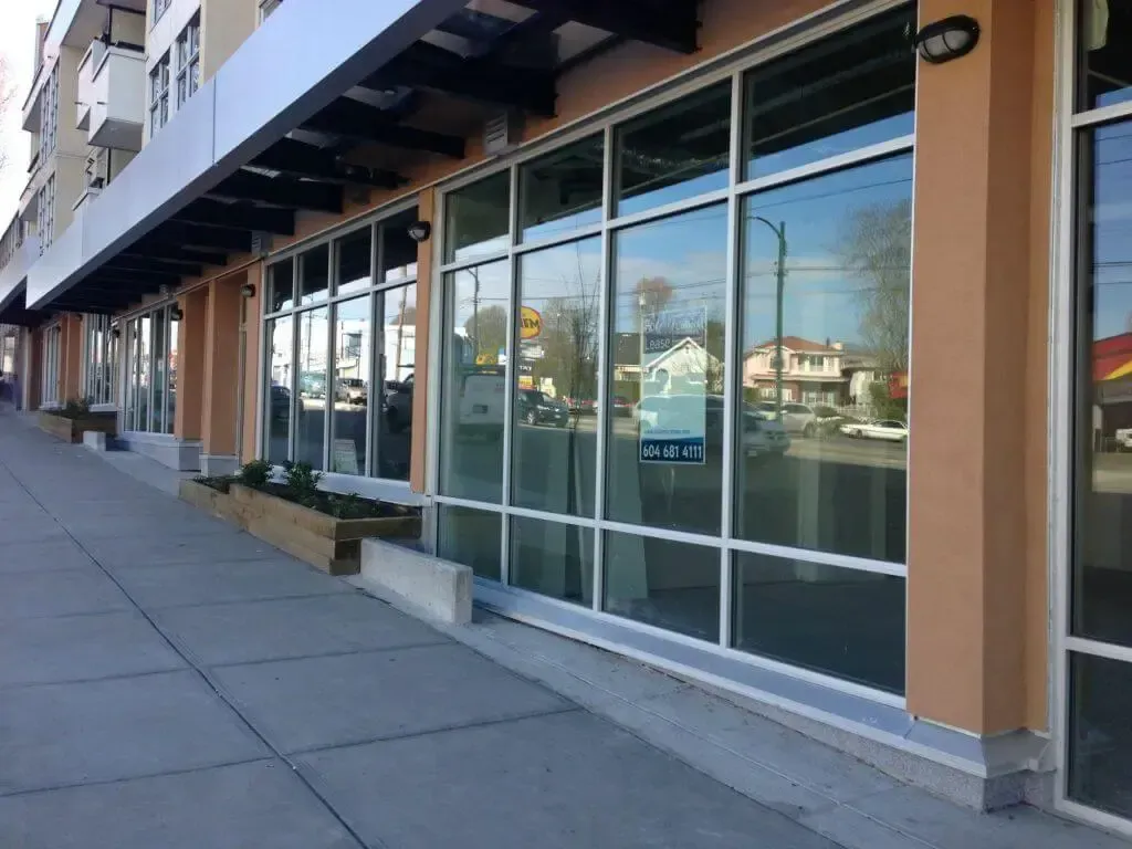 A building with a lot of windows and a sidewalk in front of it.