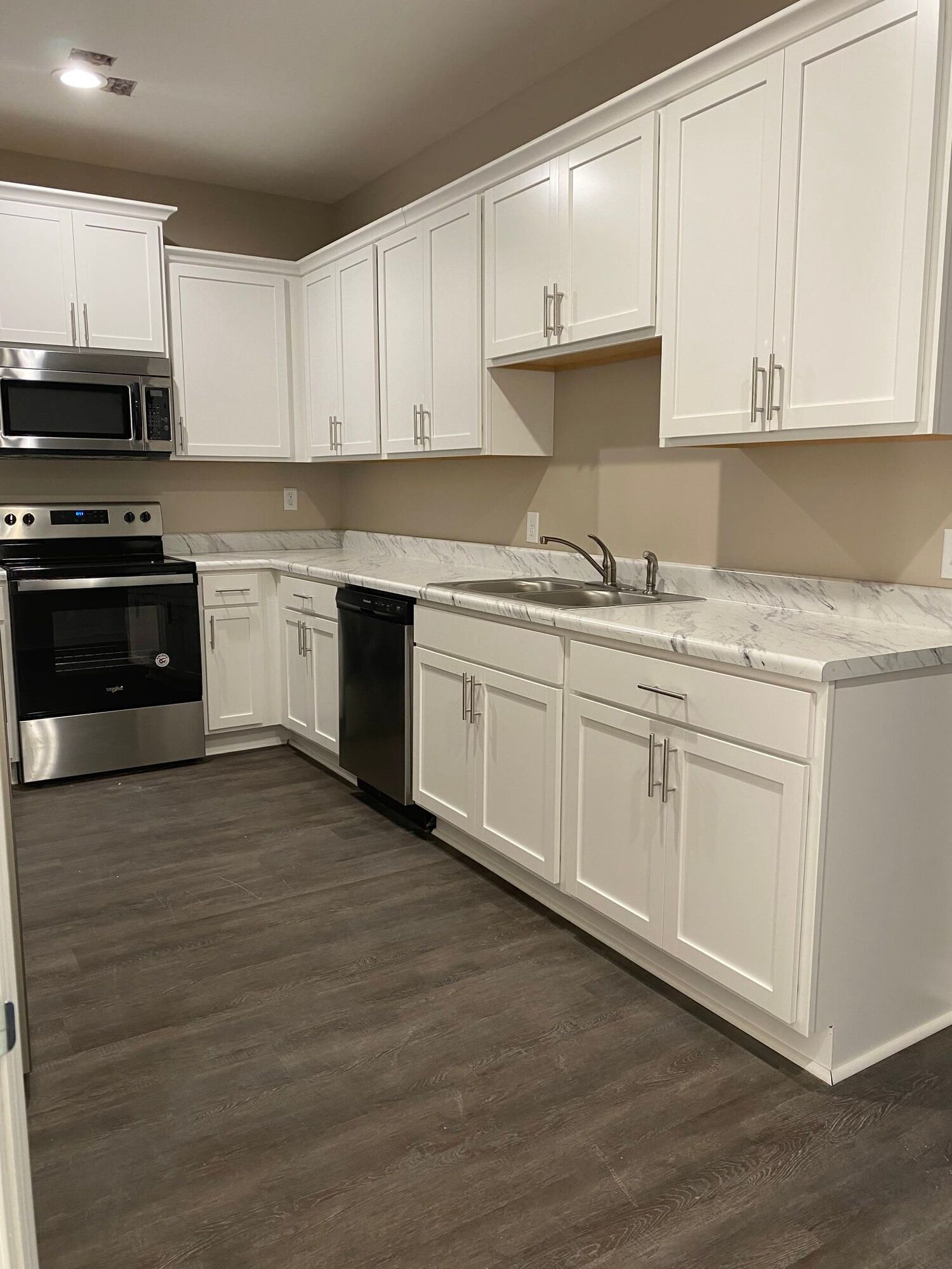 A kitchen with white cabinets and stainless steel appliances at Patriots Place.