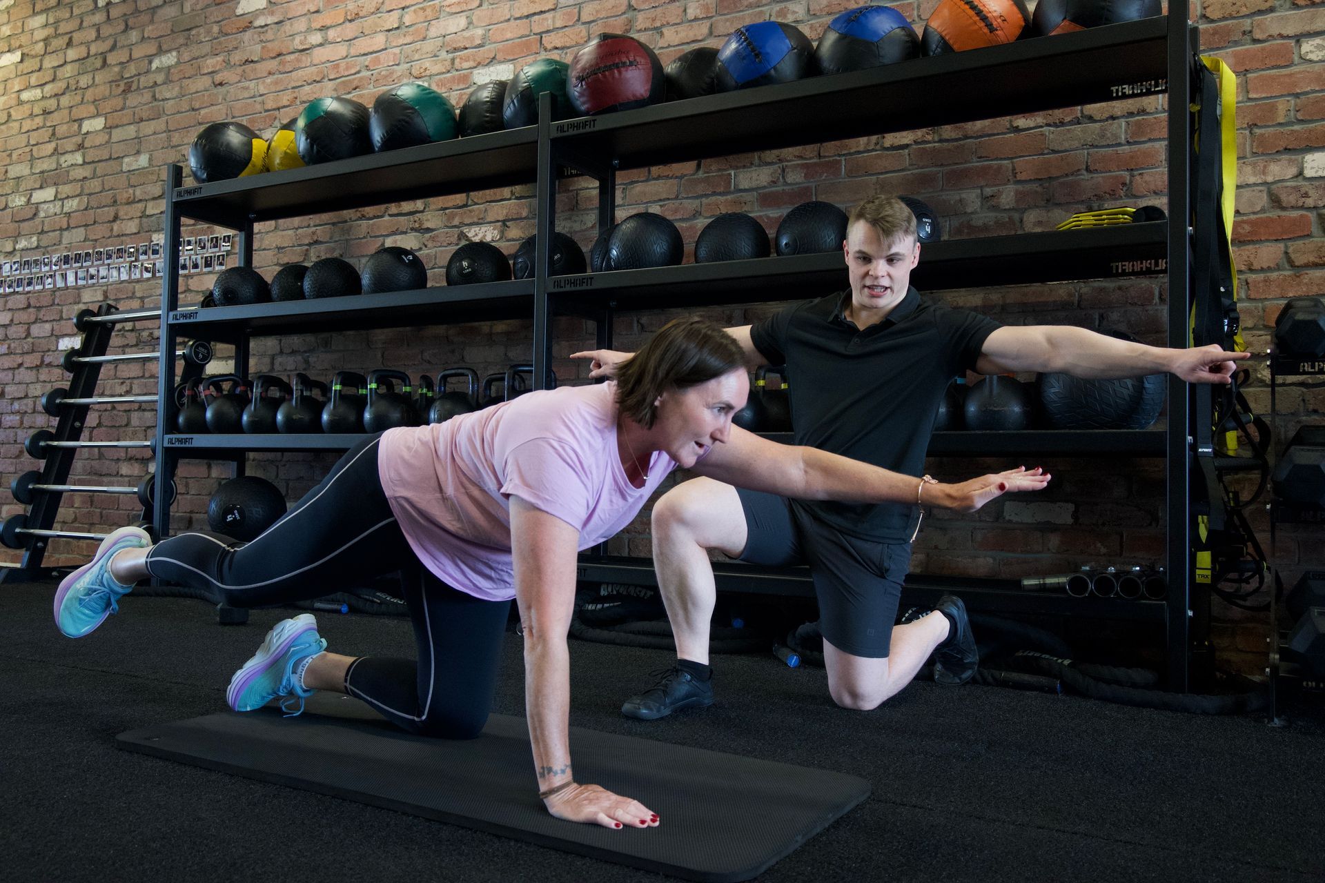 A man and a woman are doing exercises on a mat in a gym — AMC Exercise Physiology in Maitland, NSW
