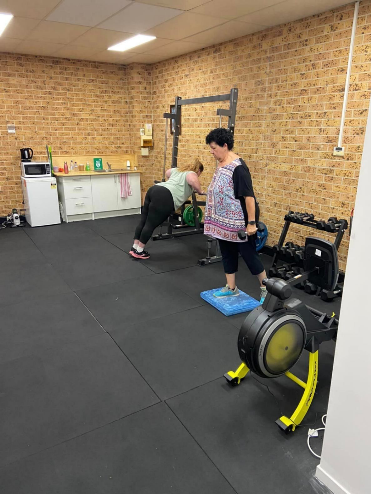 Two Women Are Doing Push Ups in A Gym — AMC Exercise Physiology in Maitland, NSW