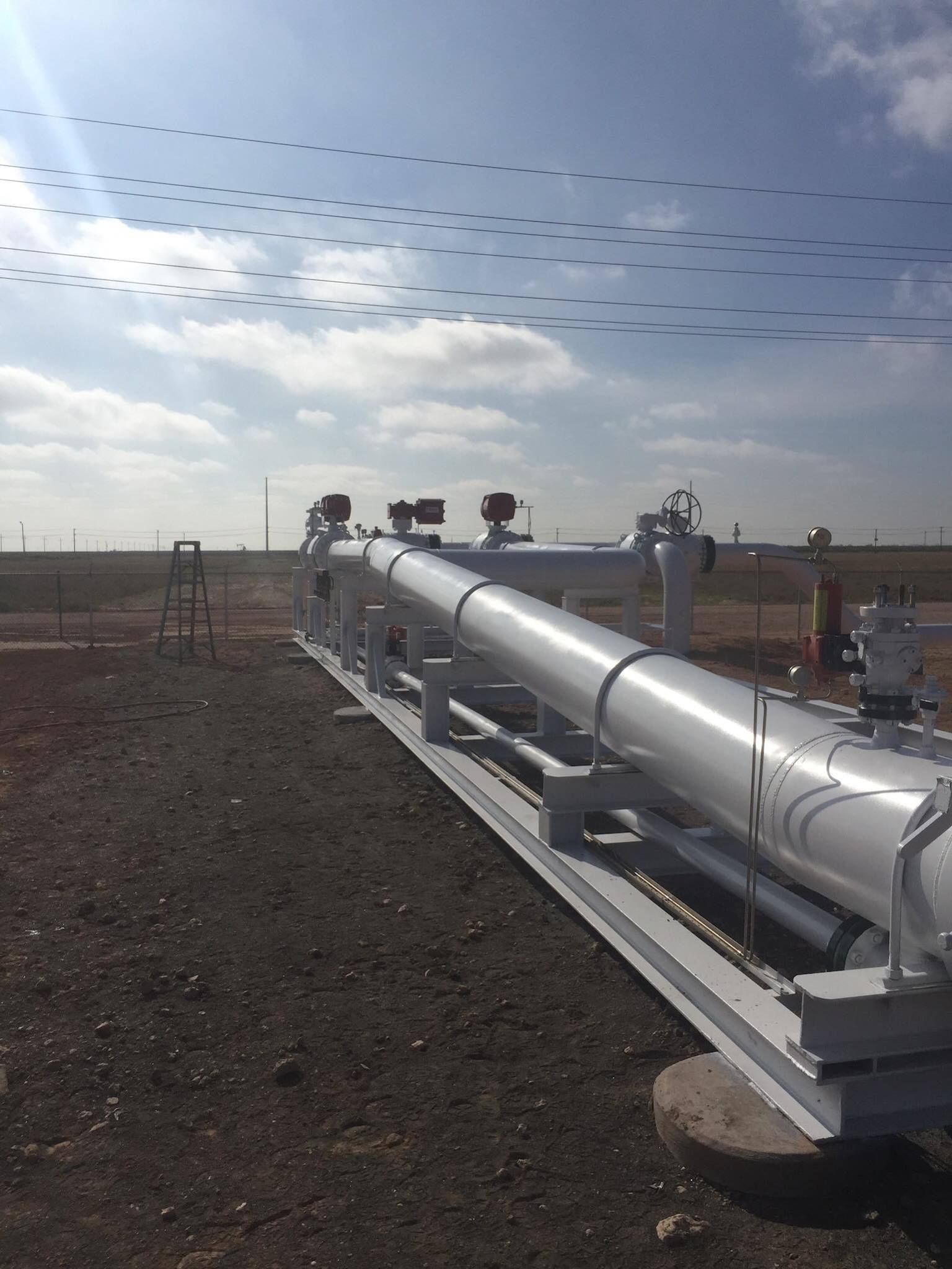 a large pipe is sitting in the middle of a dirt field .