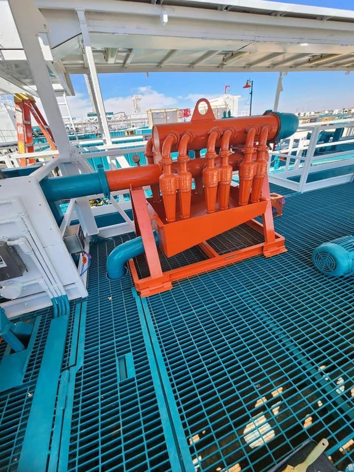 a large orange machine is sitting on top of a metal grate .