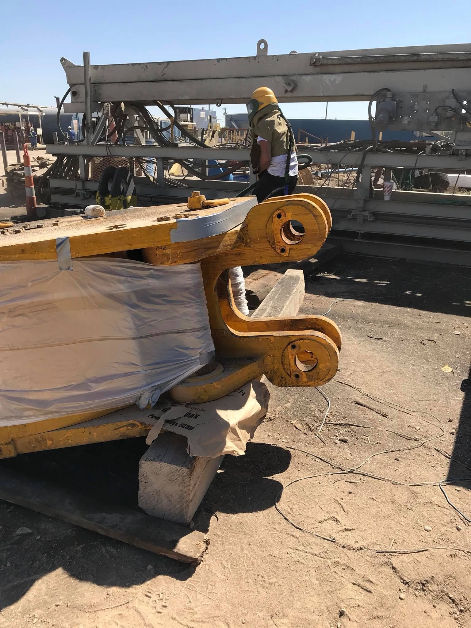a man is standing next to a large yellow object in a parking lot .