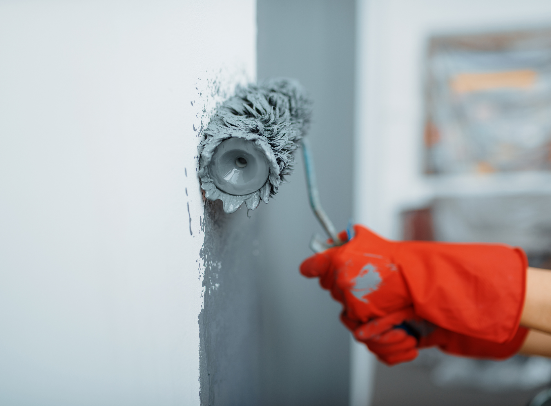 a person is painting a wall with a paint roller .