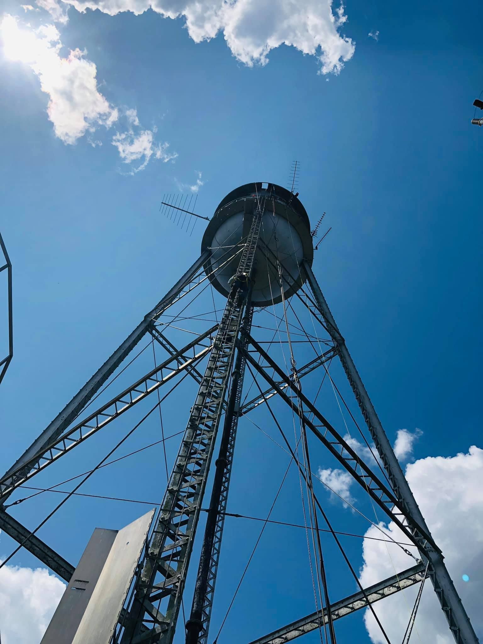 looking up at a water tower with a blue sky in the background