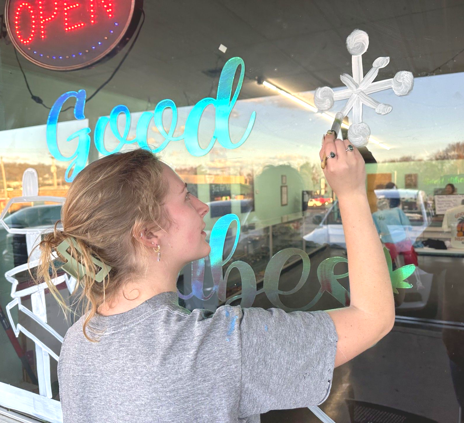 Abby Rust, artist at work on a store window