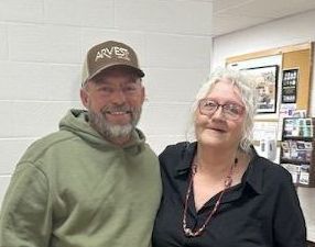 A man and a woman are posing for a picture together in a room.